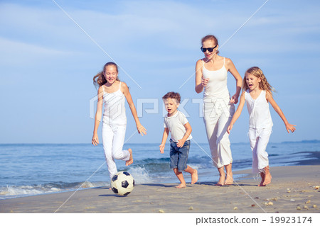 Mother and children playing on the beach at the day time. Mother and children playing on the beach at the day time. 19923174