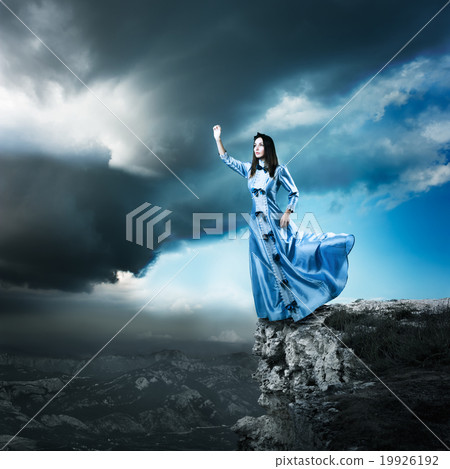 Woman in Blue Dress Reaching for the Light 19926192