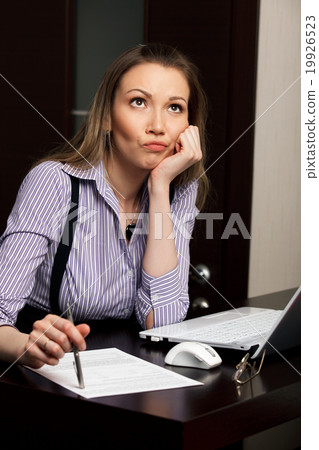 Young pretty thoughtful business woman with laptop 19926523