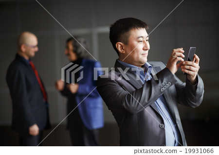 Businessman holding mobile smart phone using app Businessman holding mobile smart phone using app 19931066