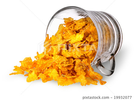 Cornflakes spill out of a glass cup Cornflakes spill out of a glass cup 19932077