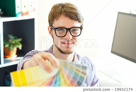 Young man looking to a color paint palette 19932174
