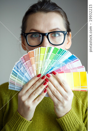 Woman with a red lips looking to a color paint palette Woman with a red lips looking to a color paint palette 19932215