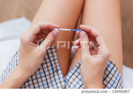 Woman in shirt  with positive pregnancy test  19940967