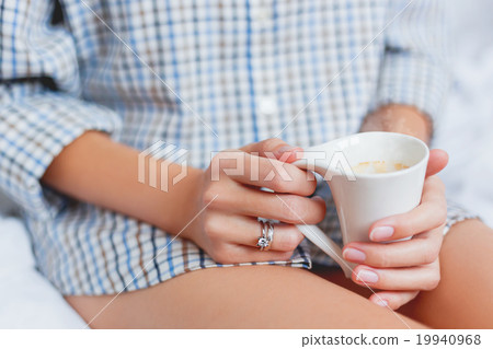 Woman in shirt with a cup with hot coffee.  19940968