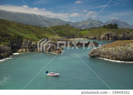 A day over a boat close to the coast and mountain 19949282