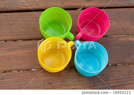 Colored cups on the wooden background 19950121