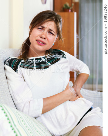 Portrait of unhappy girl having pangs of belly-ache Portrait of unhappy girl having pangs of belly-ache 19952240