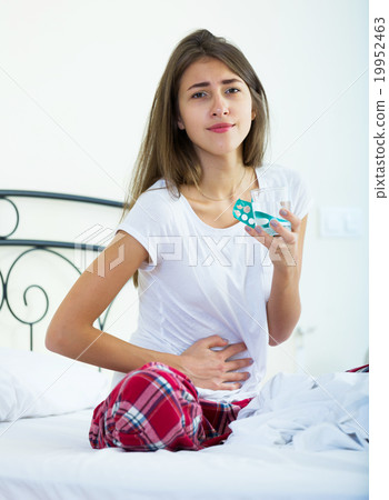 Teenage girl having belly pain and taking pills Teenage girl having belly pain and taking pills 19952463