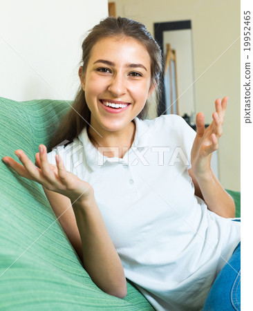 Smiling teenager girl on the couch 19952465