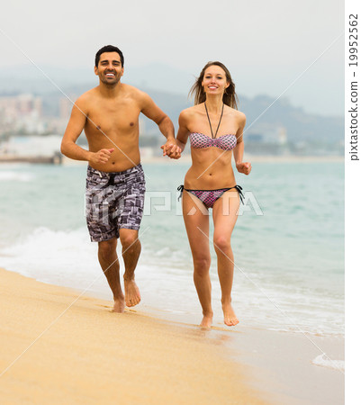 Energy couple running on the sea beach 19952562