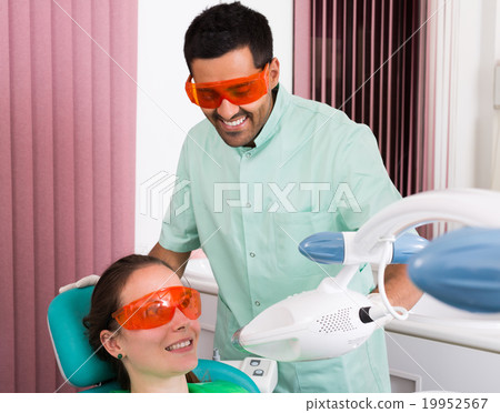 Patient at procedure of teeth whitening . Patient at procedure of teeth whitening . 19952567