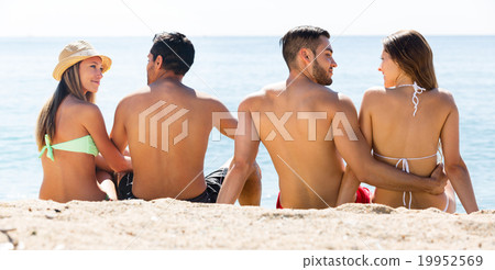 Two young couples on sand beach. 19952569
