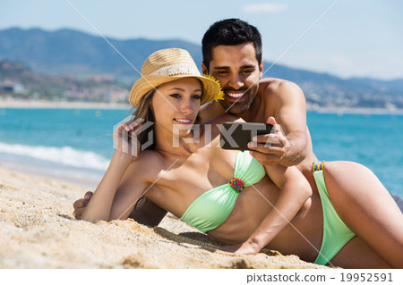Couple relaxing on beach Couple relaxing on beach 19952591