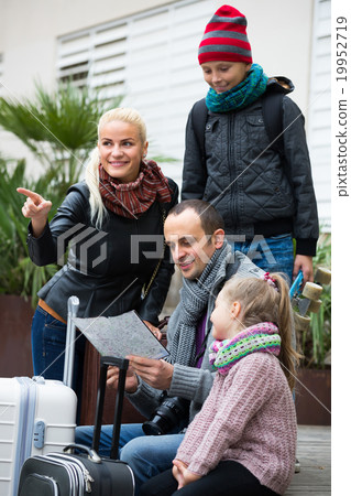 Parents with two kids and baggage with map . Parents with two kids and baggage with map . 19952719
