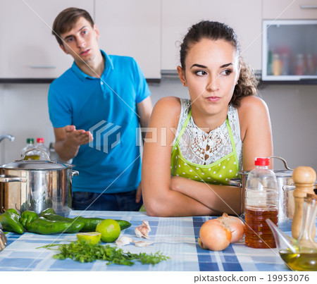 family couple with serious faces quarrelling in kitchen 19953076