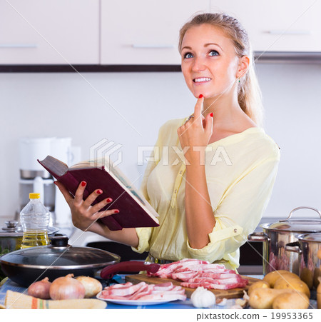 Young woman cooking meat at home. Young woman cooking meat at home. 19953365