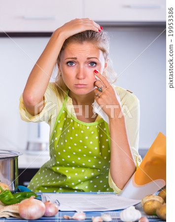 Sad girl with banking statement at home. Sad girl with banking statement at home. 19953386