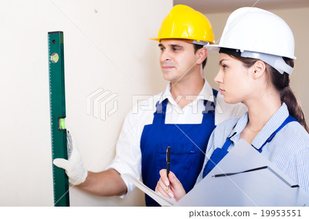 specialist and assistant working with wall in new building specialist and assistant working with wall in new building 19953551