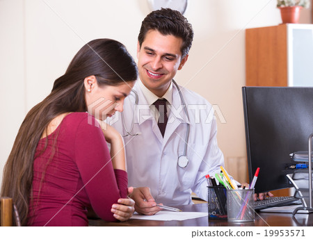 Patient and therapeutist at desk in clinic. Patient and therapeutist at desk in clinic. 19953571