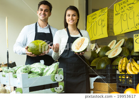 Two sellers with melon in market. 19953617