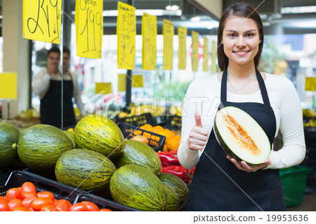 Young yseller holding musk-melon in market Young yseller holding musk-melon in market 19953636