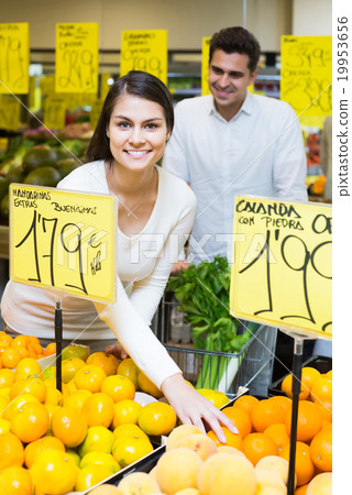 couple buying fresh seasonal fruits in market 19953656