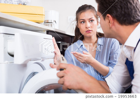Specialist in uniform with tools and young woman washing machine Specialist in uniform with tools and young woman washing machine 19953663