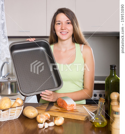 Smiling housewife cooking salmon Smiling housewife cooking salmon 19953890