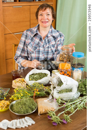 Mature woman with herbs at table 19953946