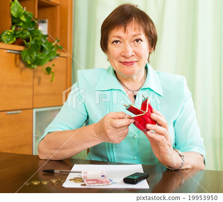 Woman sitting at the table with money and bills Woman sitting at the table with money and bills 19953950