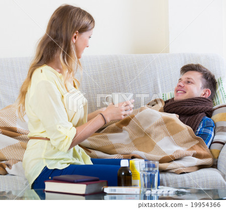 Wife taking care of young husband with flue at home 19954366