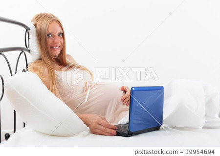 pregnancy woman in nightdress with laptop pregnancy woman in nightdress with laptop 19954694