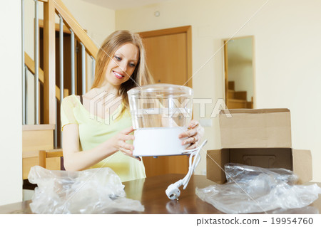 young housewife unpacking new steamer 19954760
