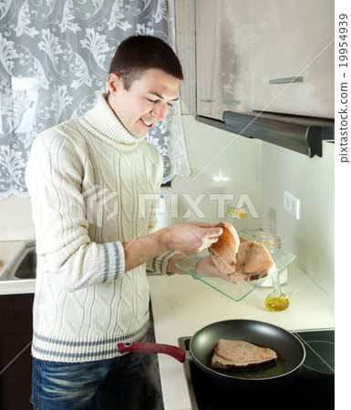 guy frying steak of fish 19954939