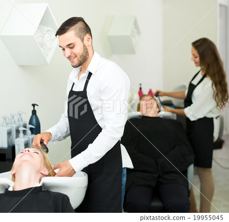 Hairstylist washing head of woman Hairstylist washing head of woman 19955045