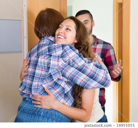 Mother greeting happy young couple 19955055