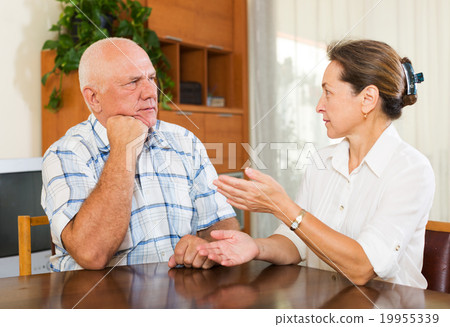 Serious elderly couple talking in home 19955339