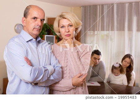 Couple with kid and bills at table and sad parents apart Couple with kid and bills at table and sad parents apart 19955483