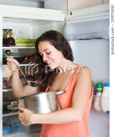 Hungry girl eating from pan 19955692