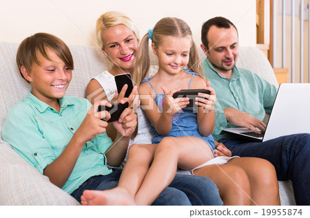 Portrait of family playing with gadgets at home 19955874