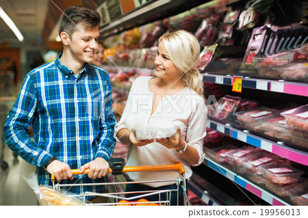 Happy family couple choosing chilled meat Happy family couple choosing chilled meat 19956013