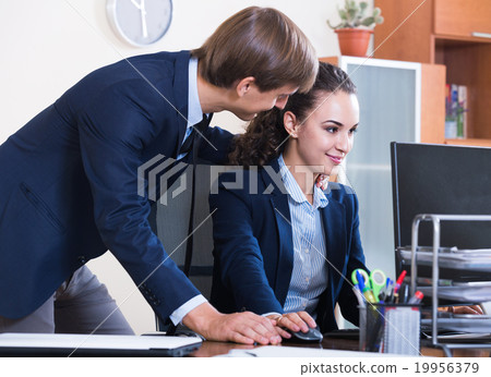 Top manager flirting with subordinate official at workplace 19956379