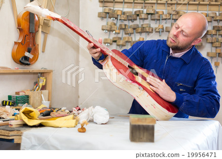 Guitar-maker at workshop. 19956471