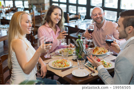 Young people enjoying food at tavern 19956505