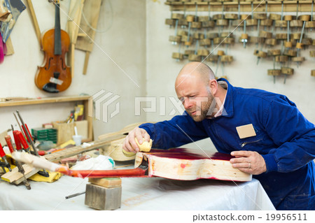 craftsman working with unfinished guitar craftsman working with unfinished guitar 19956511