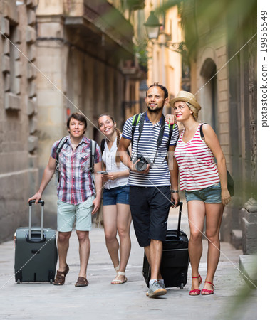Couples with baggage walking the city. 19956549
