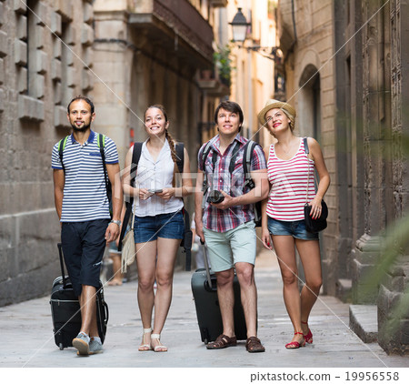 Couples with baggage walking the city. 19956558