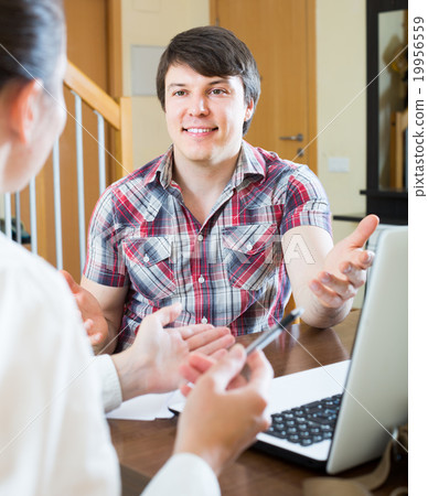 Girl talks with man while interviewing him at home Girl talks with man while interviewing him at home 19956559