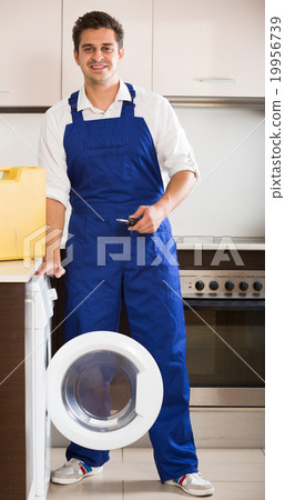 Happy specialist with tooling near washing machine Happy specialist with tooling near washing machine 19956739